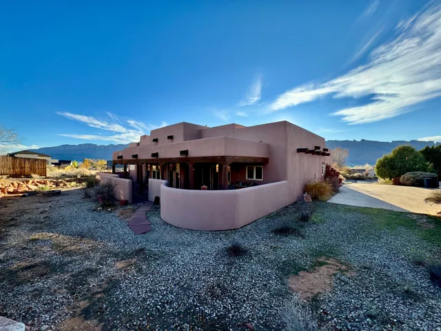 Back of house featuring a mountain view, stucco siding, and a patio