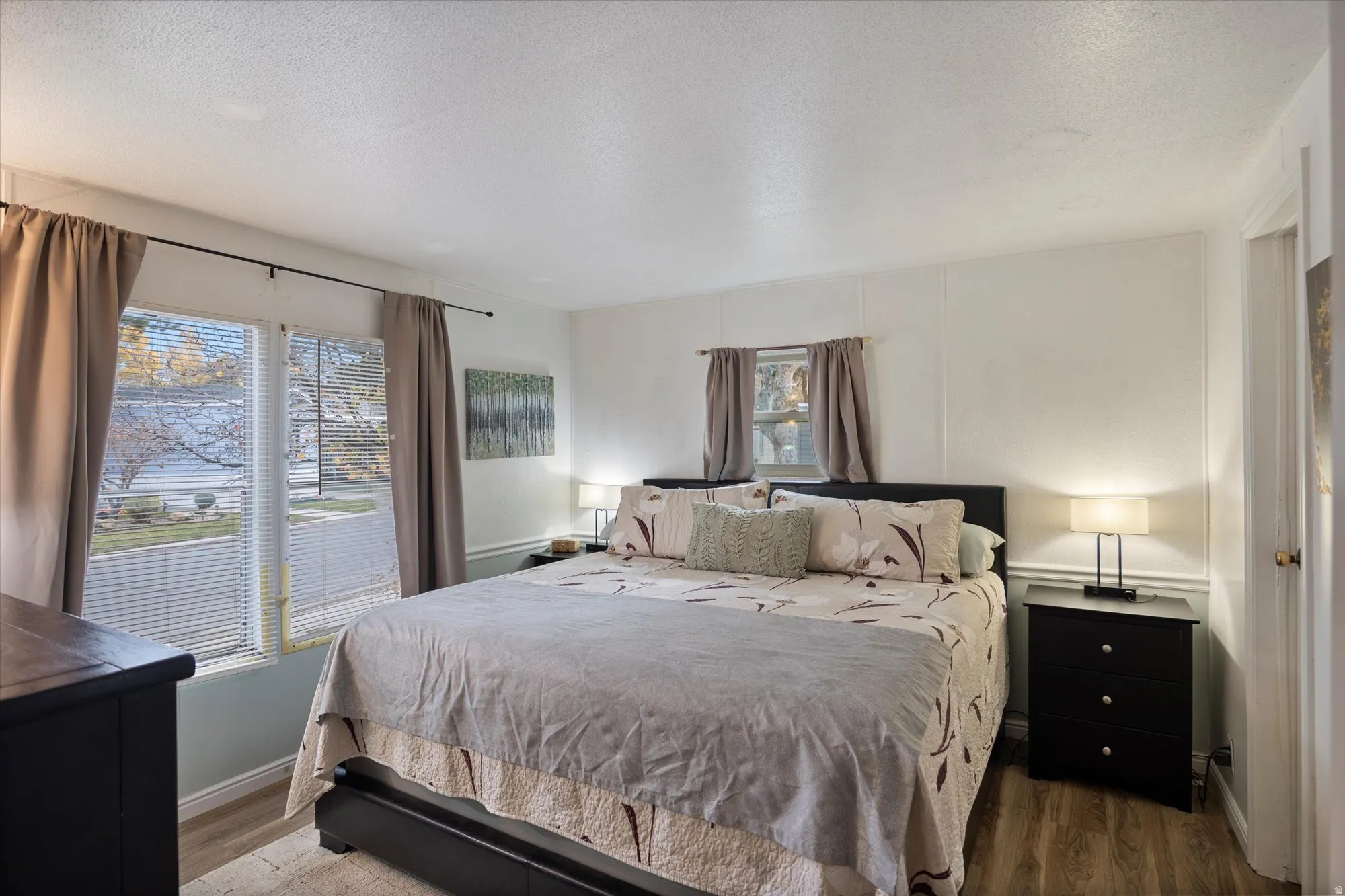 Primary bedroom featuring a textured ceiling and wood finished floors