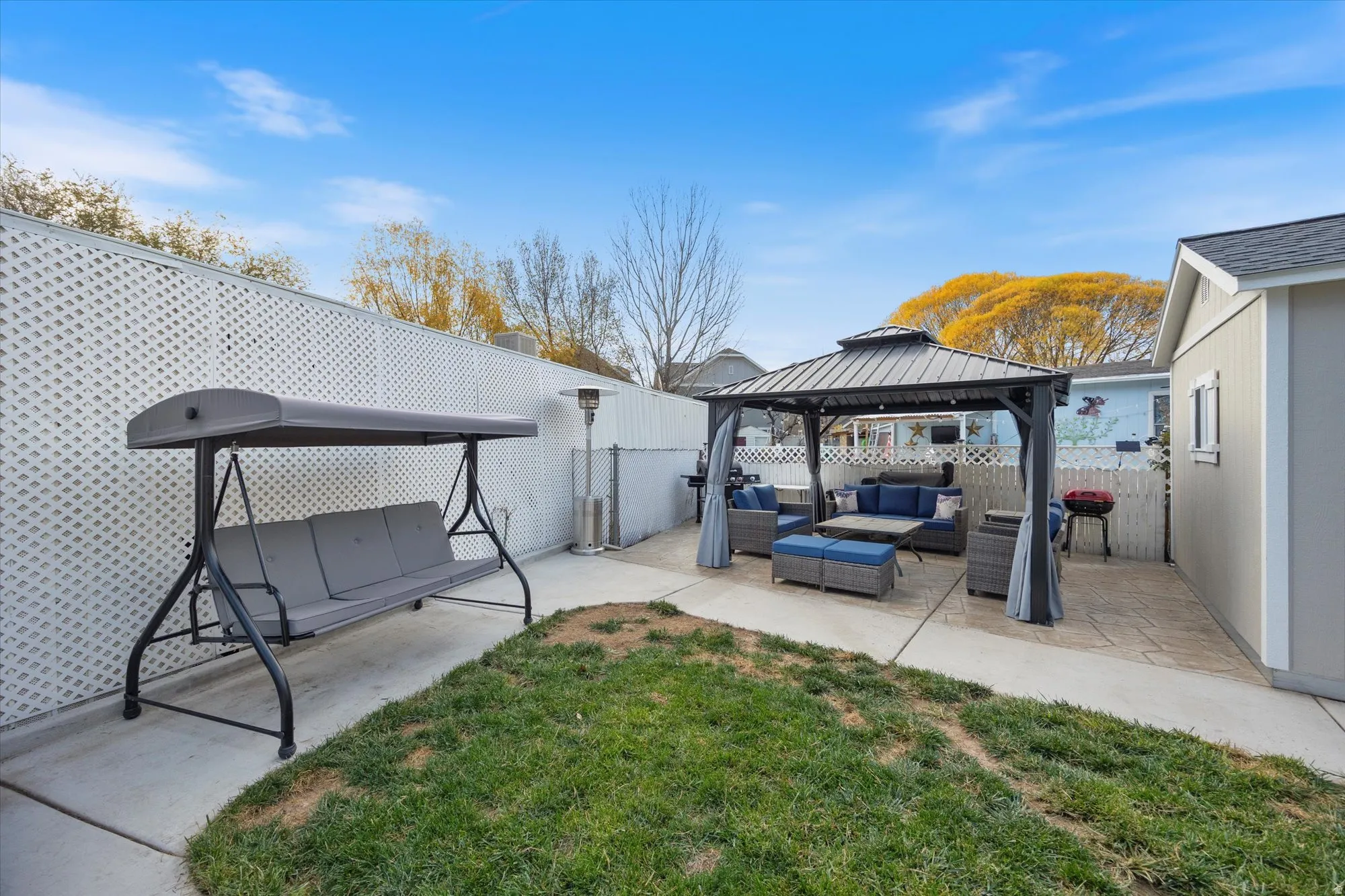 Fenced backyard with an outdoor hangout area, a gazebo, and a patio