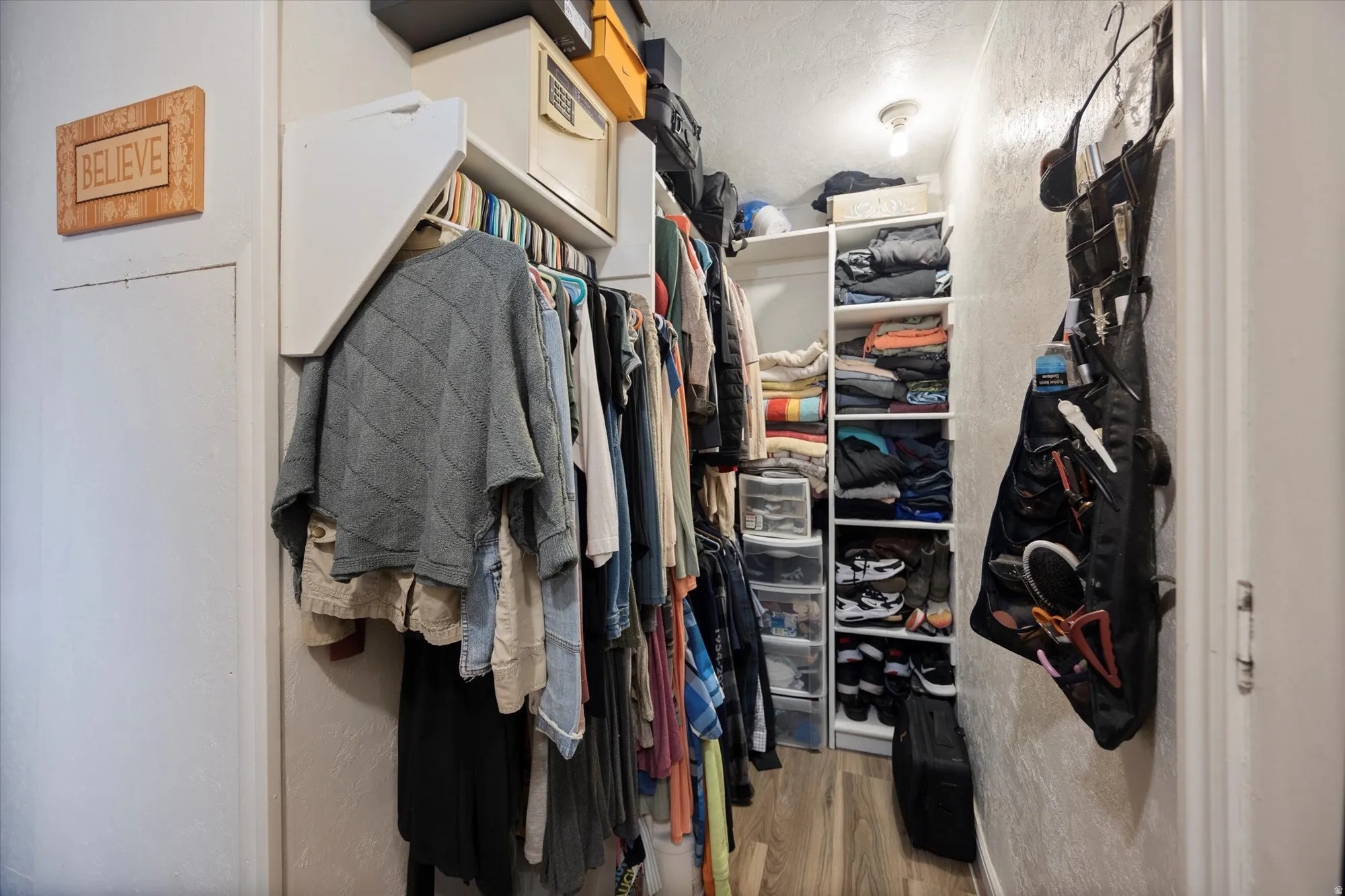 Primary walk in closet with light wood-type flooring