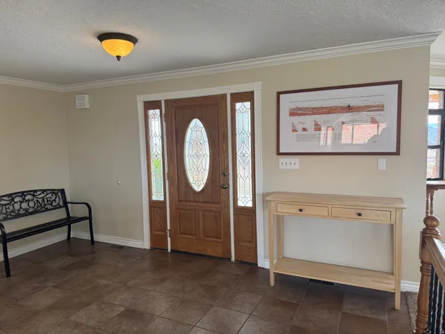 Foyer with a textured ceiling and crown molding