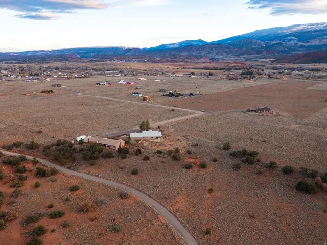 Aerial view of property and surrounding area with rural landscape and a mountainous background