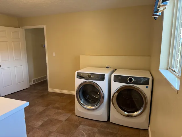 Laundry mud room featuring separate washer and dryer and a textured ceiling