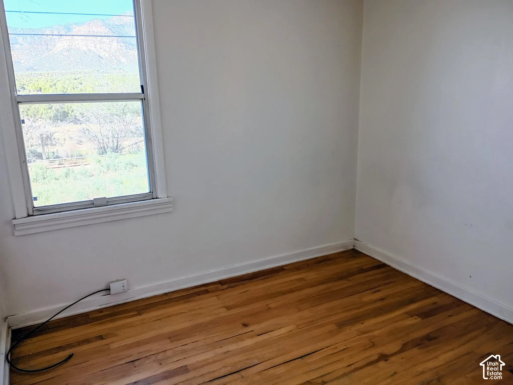Hardwood flooring, white wall paint, white trim, double-hung window, mountain scenery