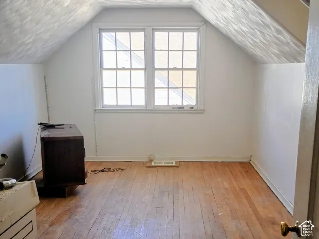 Hardwood flooring, painted walls, attic skylight, and double-hung windows