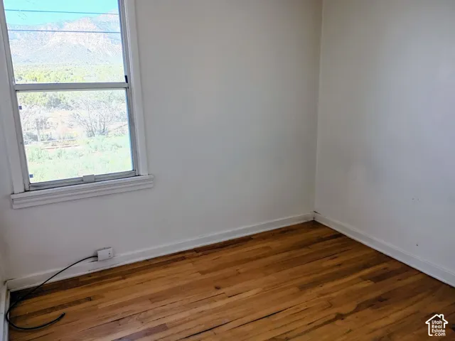 Hardwood flooring, white wall paint, white trim, double-hung window, mountain scenery