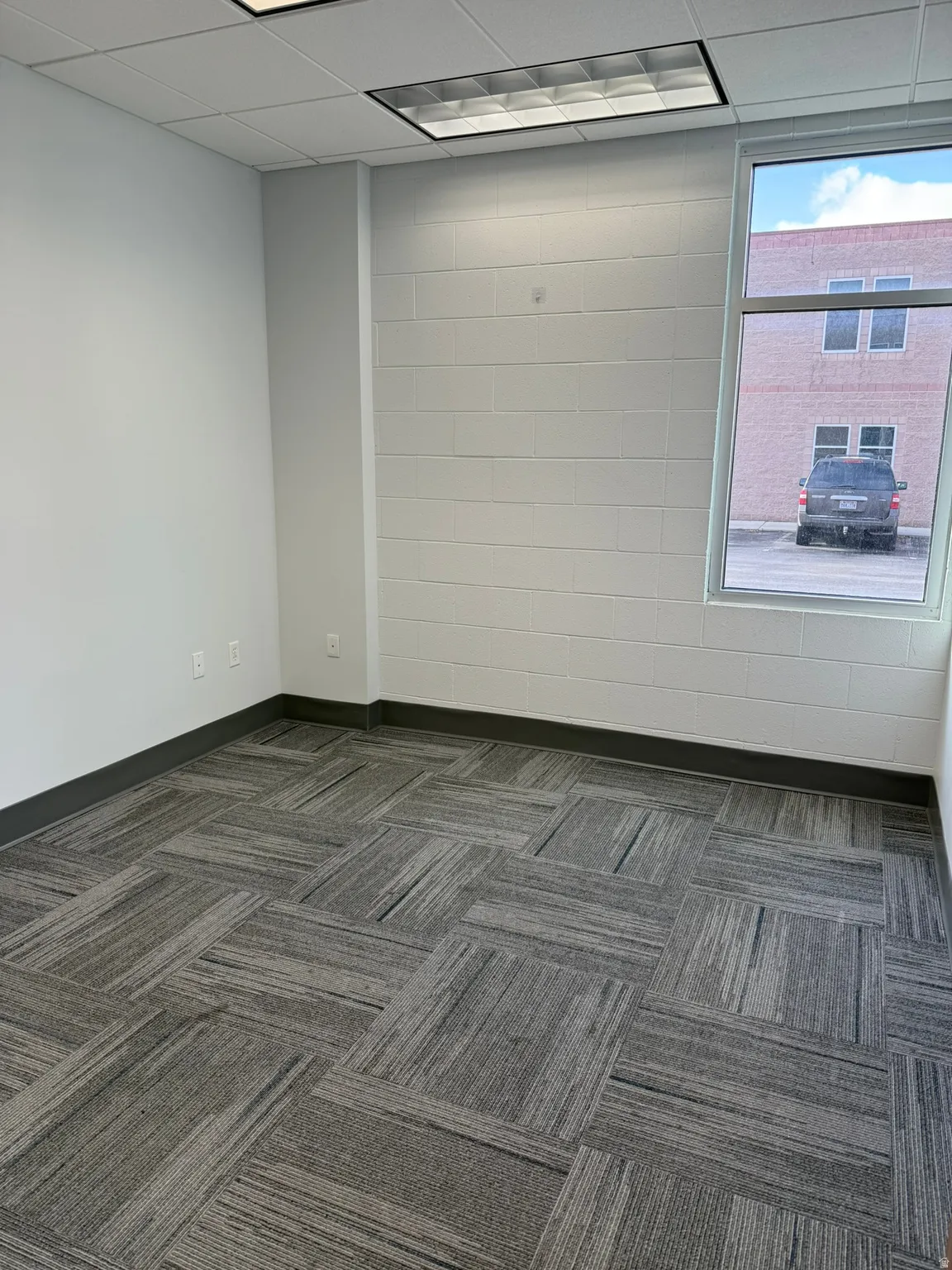 Spare room with dark carpet and a drop ceiling