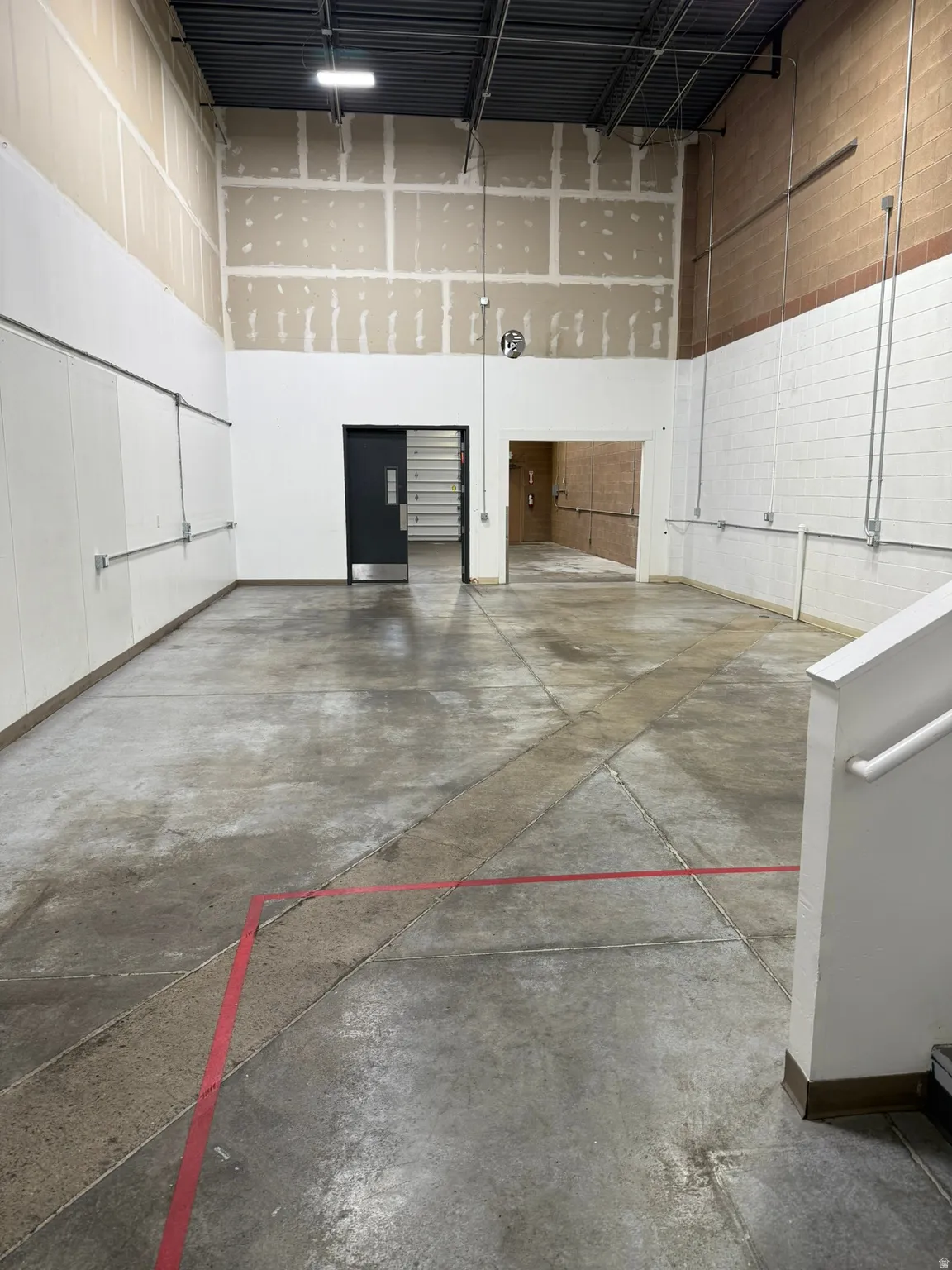 Misc room featuring a towering ceiling and a garage