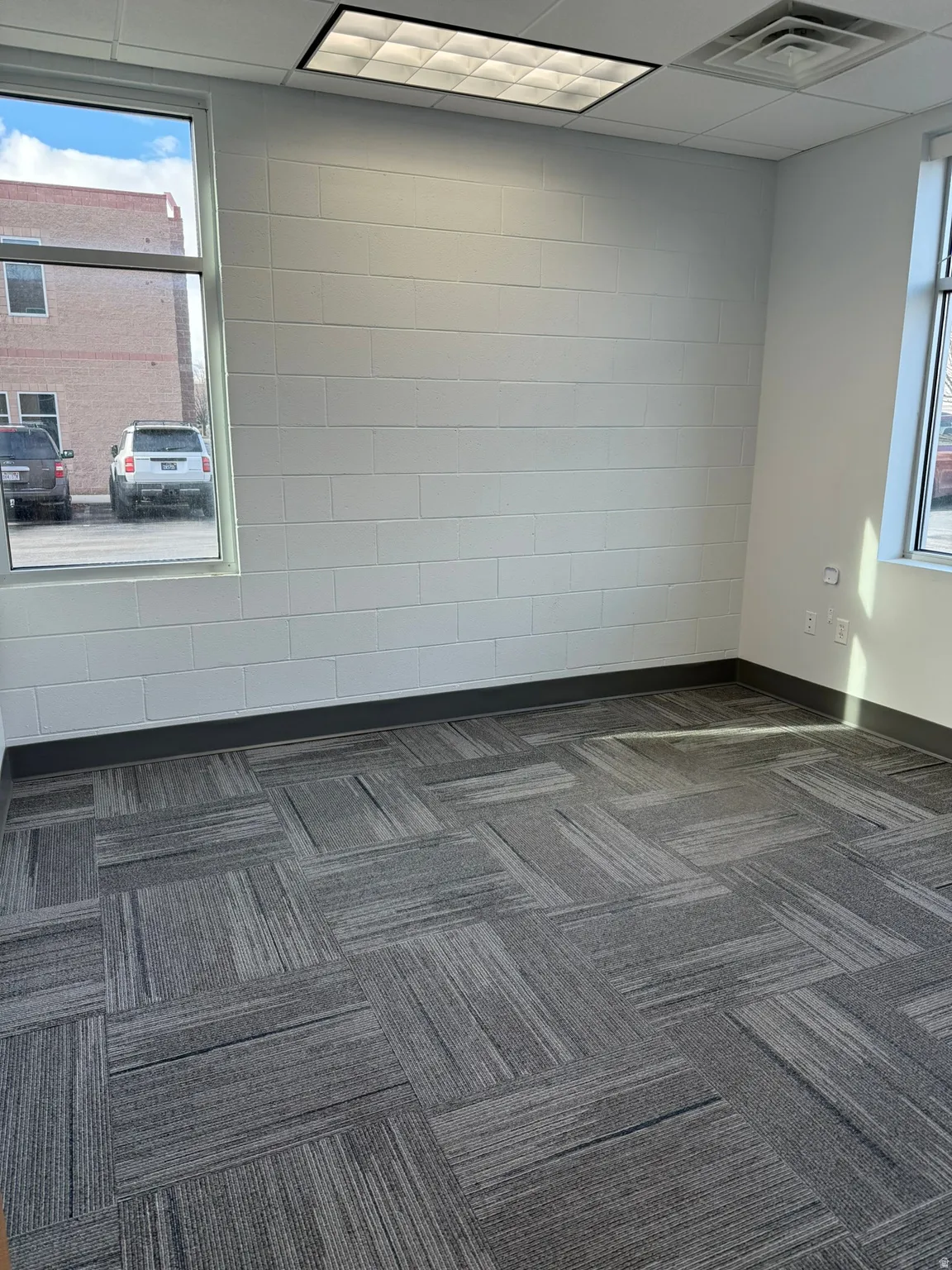 Empty room with baseboards and dark colored carpet