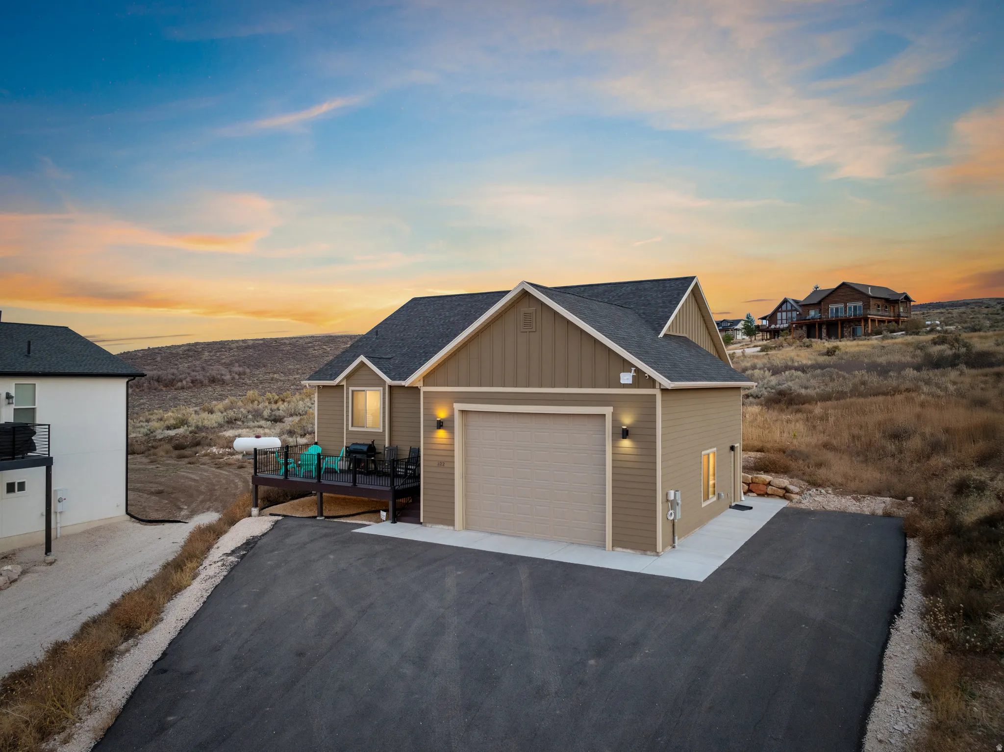 View of front of home with board and batten siding, a shingled roof, and asphalt driveway