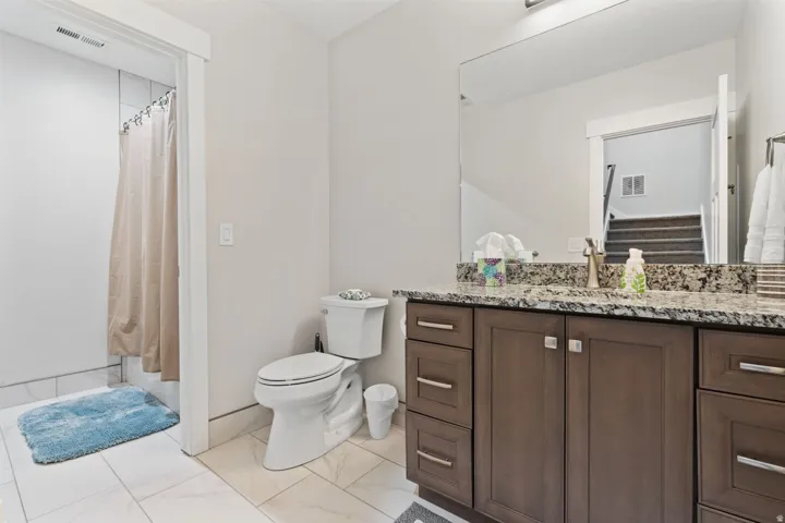 Full bath with vanity, a shower with curtain, and light marble finish floors