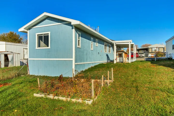 View of side of property with a yard and a pergola