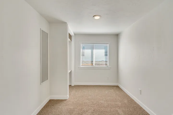 Empty room with light carpet and baseboards