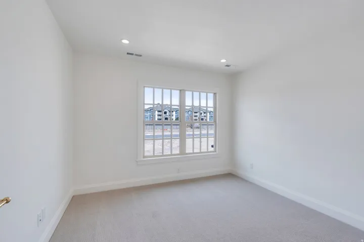 Spare room featuring light colored carpet and recessed lighting