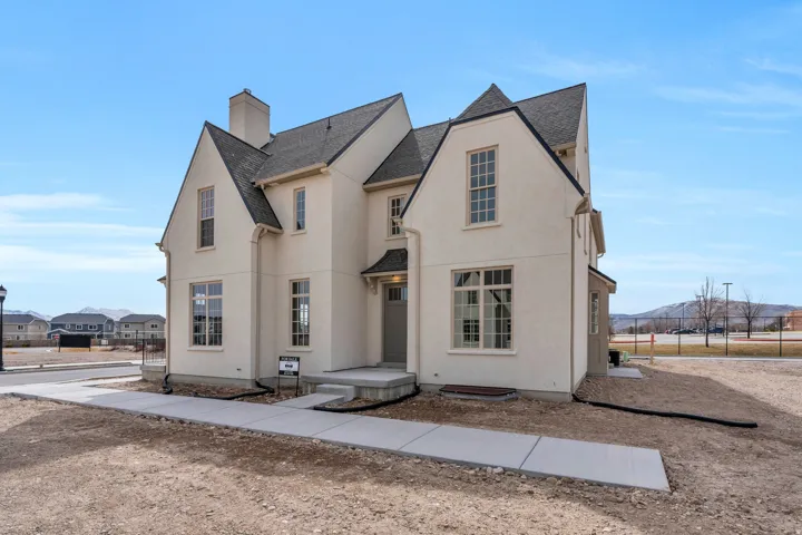 Rear view of property with roof with shingles, a chimney, stucco siding, and a mountain view