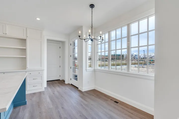 Unfurnished dining area featuring light wood-style flooring, a chandelier, and recessed lighting