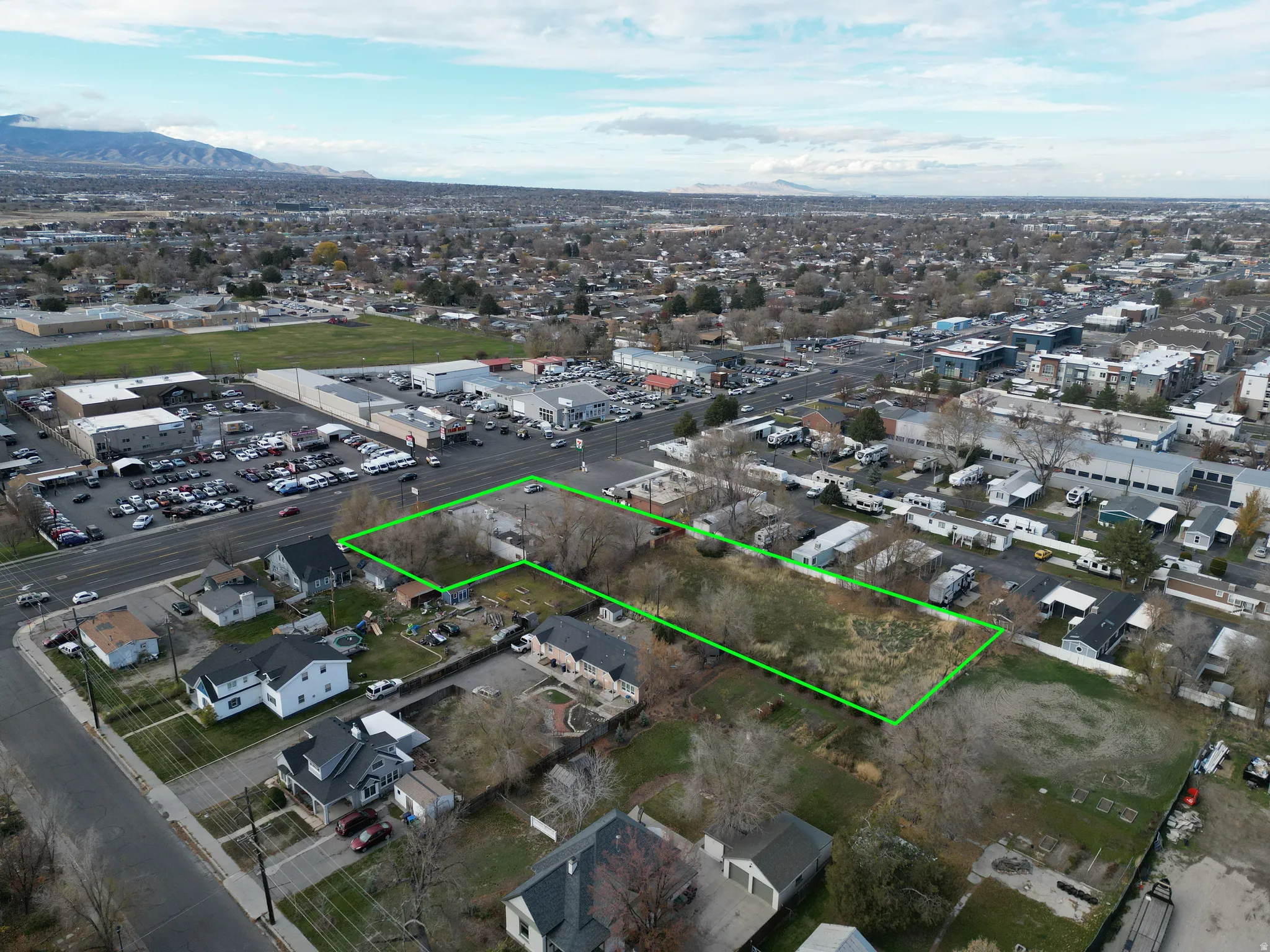 Aerial view of residential area featuring property boundaries highlighted and mountains