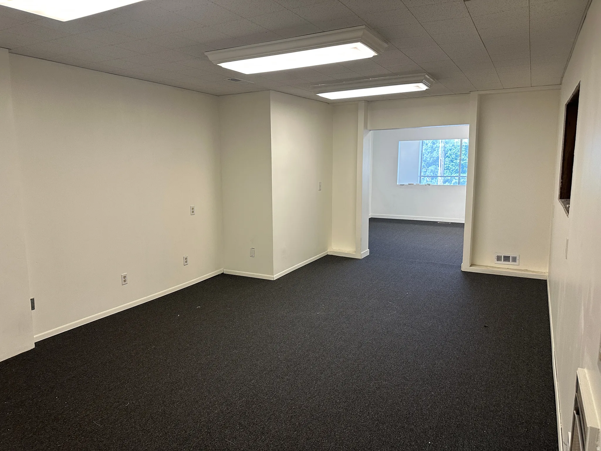 Unfurnished room with dark carpet and baseboards