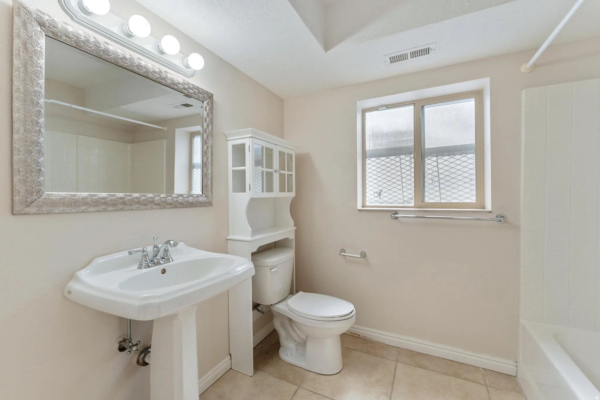 Full bathroom featuring light tile patterned flooring and shower / tub combination
