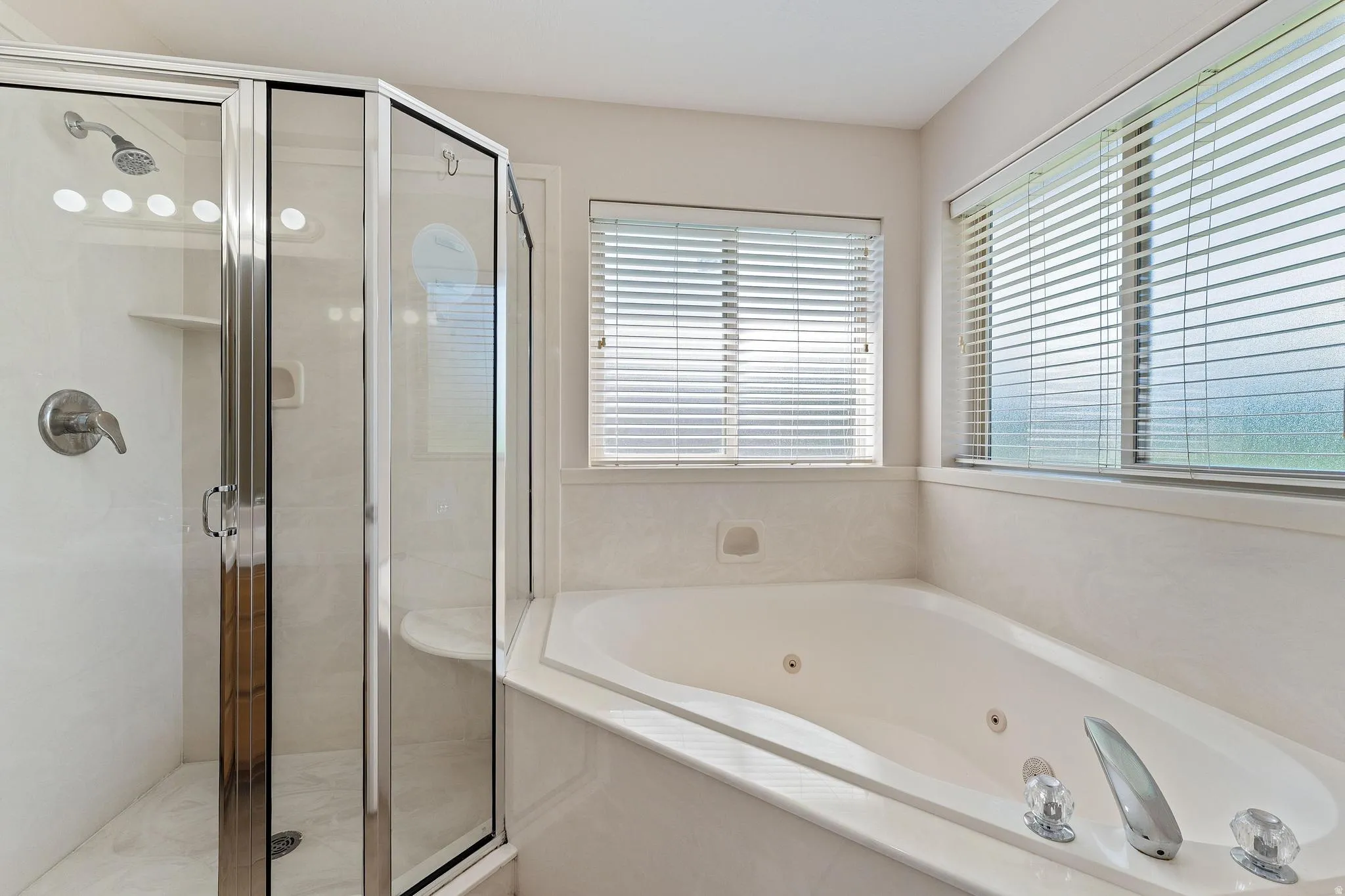 Full bathroom with a whirlpool tub and a stall shower