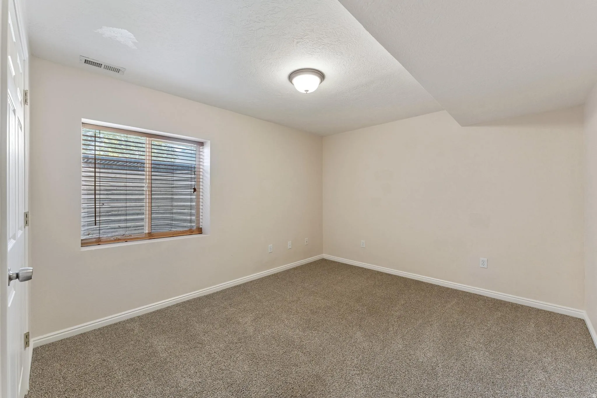 Empty room featuring carpet flooring and a textured ceiling