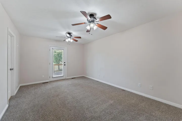 Spare room with light colored carpet and ceiling fan