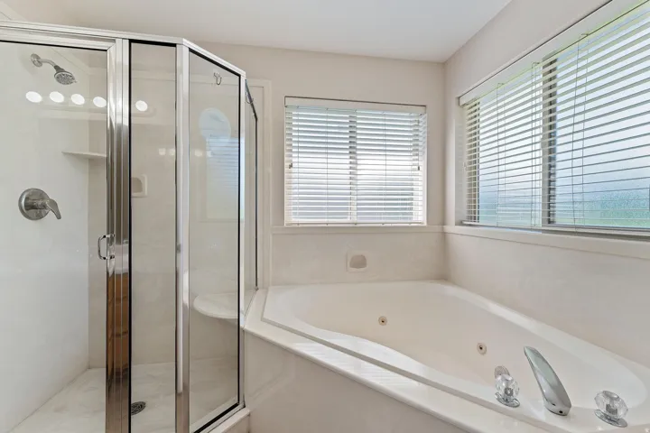 Full bathroom with a whirlpool tub and a stall shower
