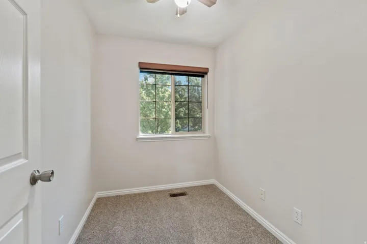 Unfurnished room featuring carpet and a ceiling fan