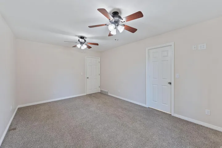 Unfurnished room with light carpet and a ceiling fan