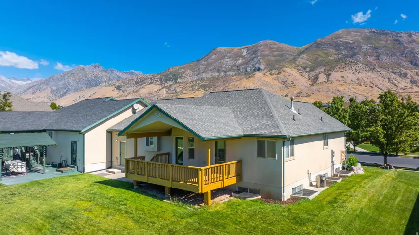 Back of house with a lawn, a patio, and stucco siding