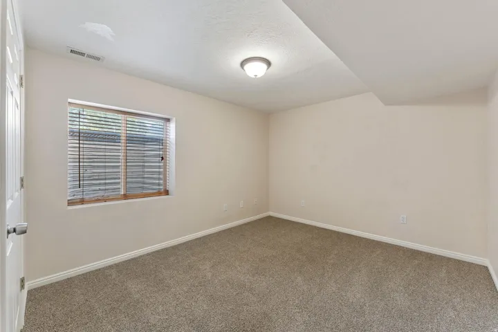Empty room featuring carpet flooring and a textured ceiling