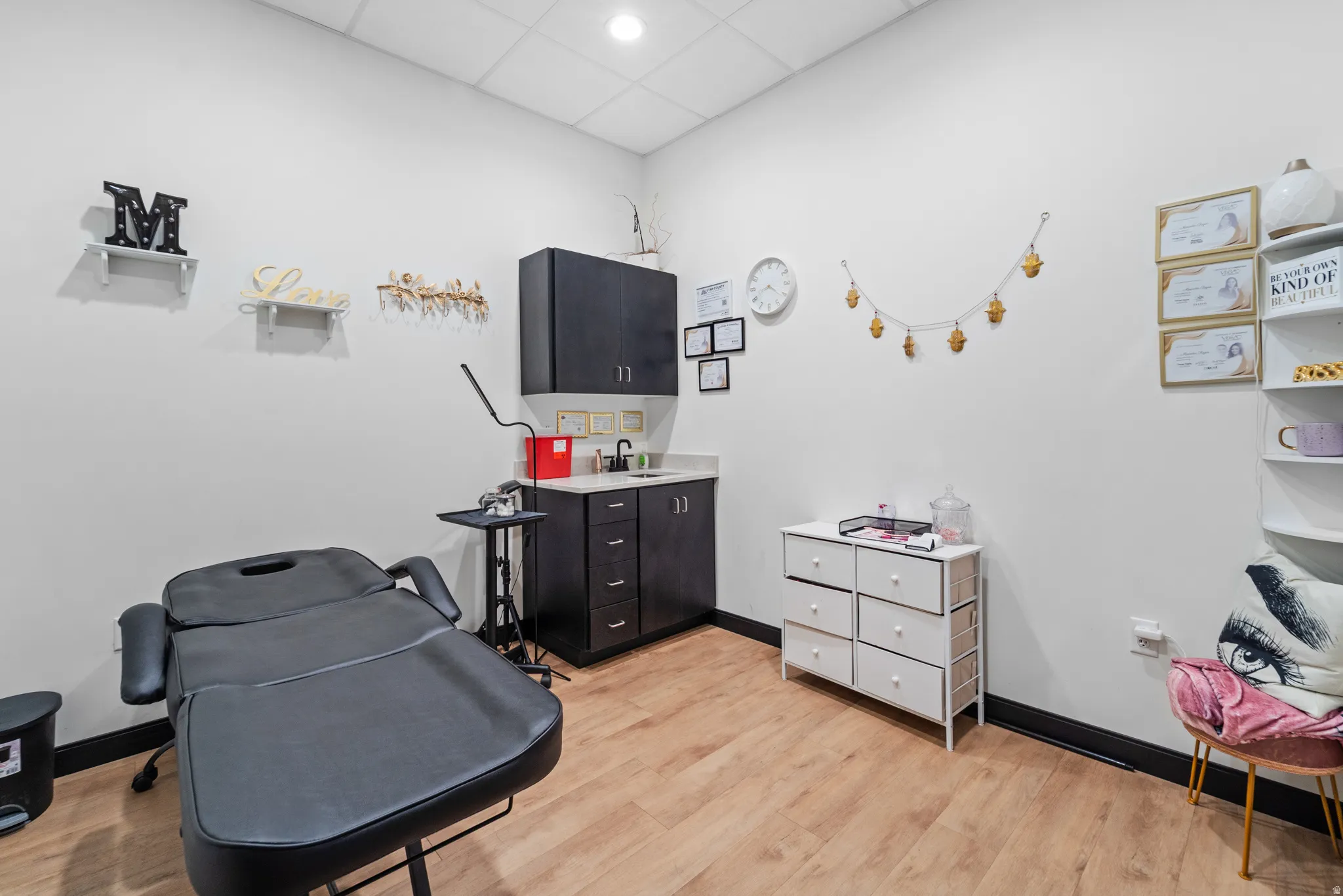 Miscellaneous room featuring a drop ceiling and light wood-style floors