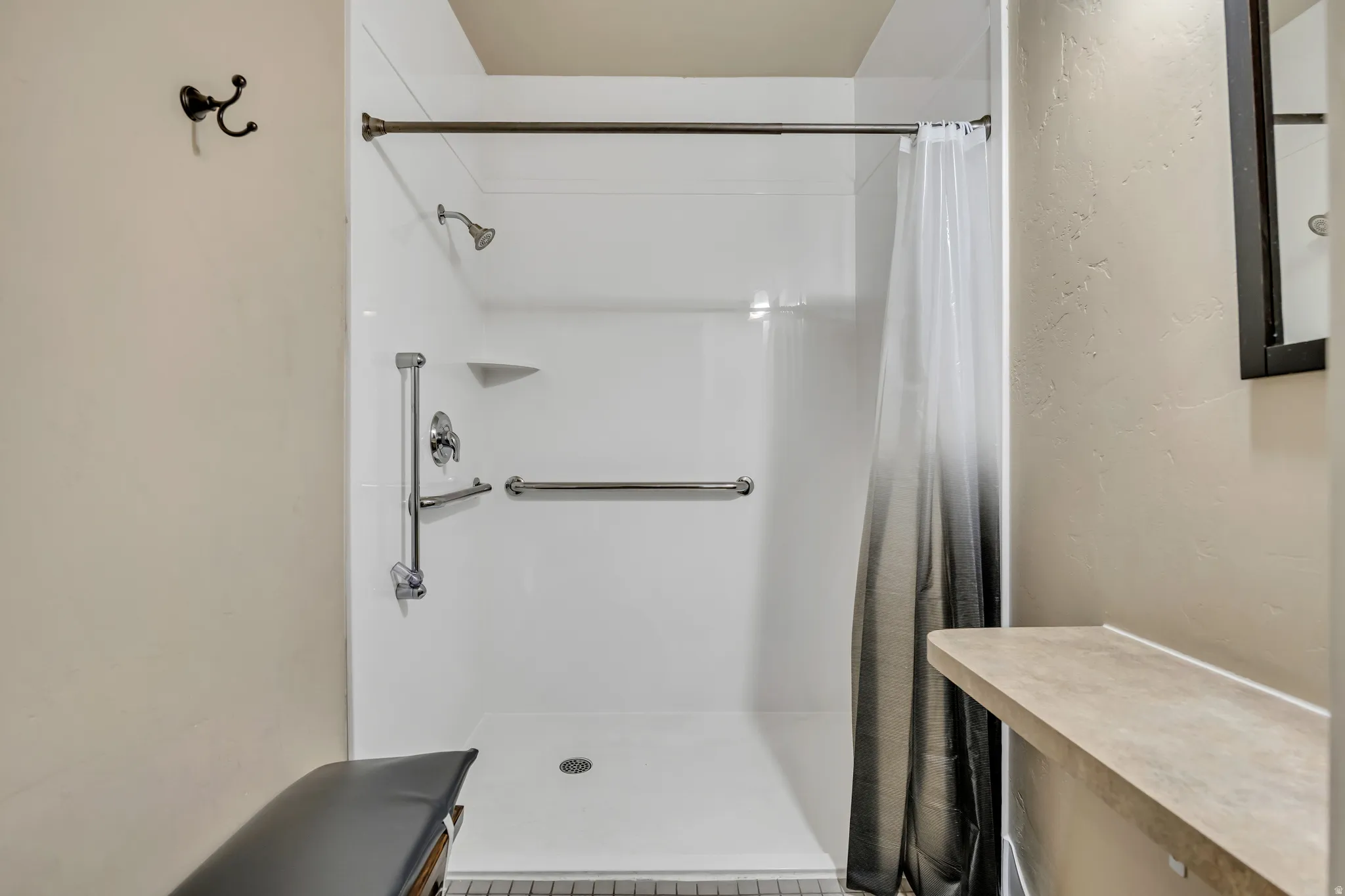 Bathroom featuring a shower with curtain and a textured wall