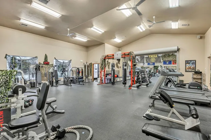 Gym with ceiling fan and vaulted ceiling