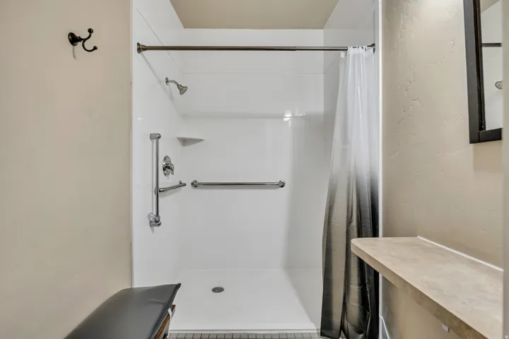 Bathroom featuring a shower with curtain and a textured wall