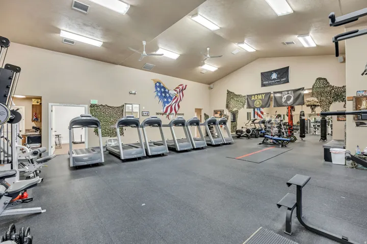 Workout area featuring a ceiling fan and high vaulted ceiling