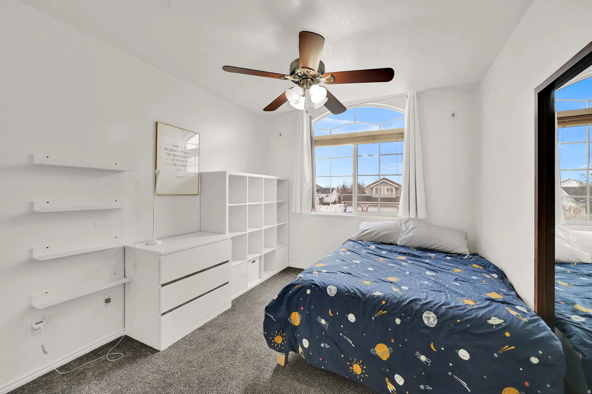 Carpeted bedroom with ceiling fan