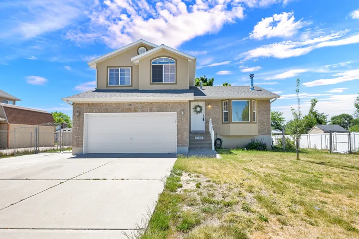 Two-story residence featuring a two-car garage, concrete driveway, stone facade, and bay window