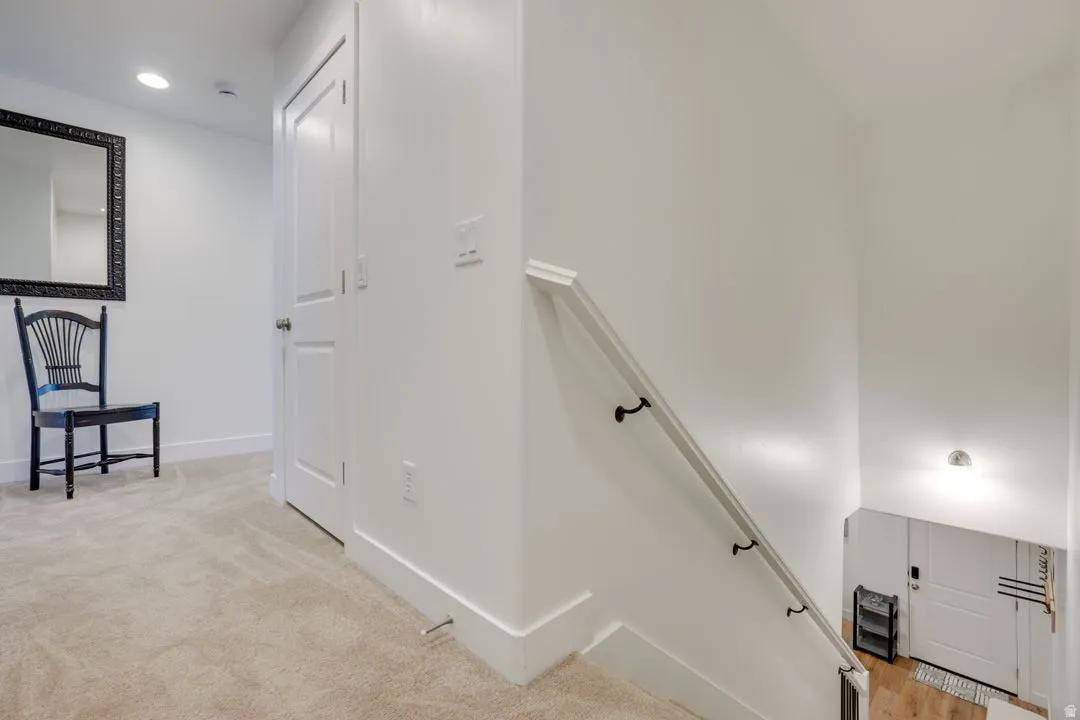 Staircase with carpet flooring and recessed lighting