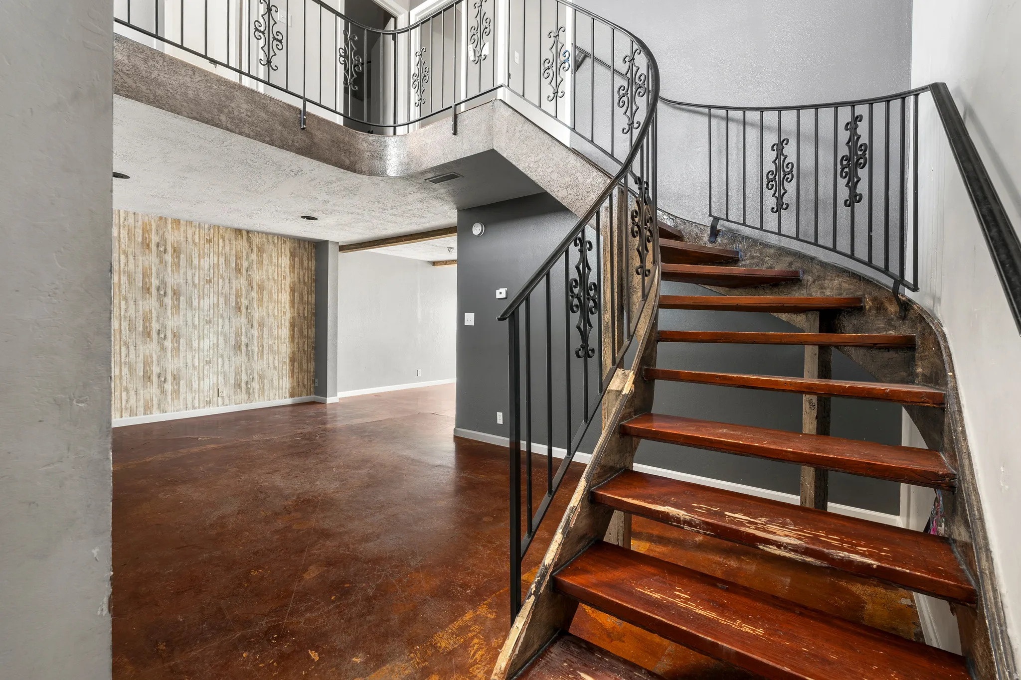 Stairway featuring a high ceiling and finished concrete flooring