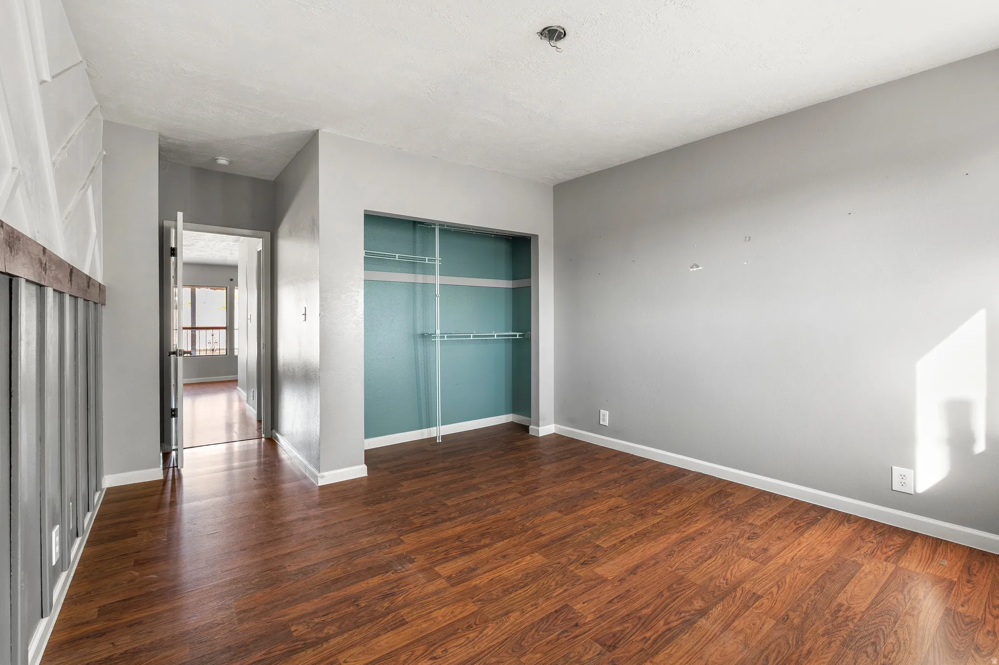 Unfurnished bedroom featuring a closet and dark wood finished floors