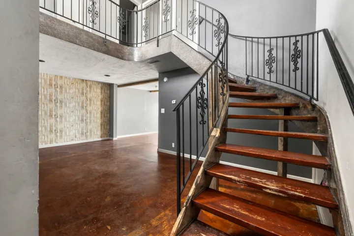 Stairway featuring a high ceiling and finished concrete flooring