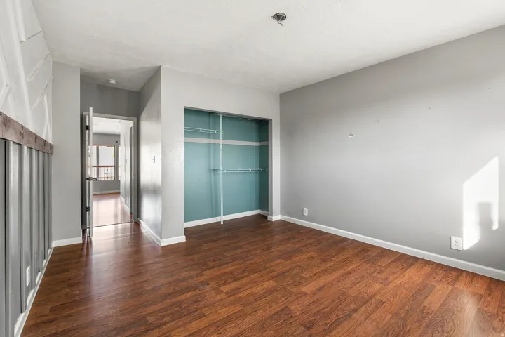 Unfurnished bedroom featuring a closet and dark wood finished floors