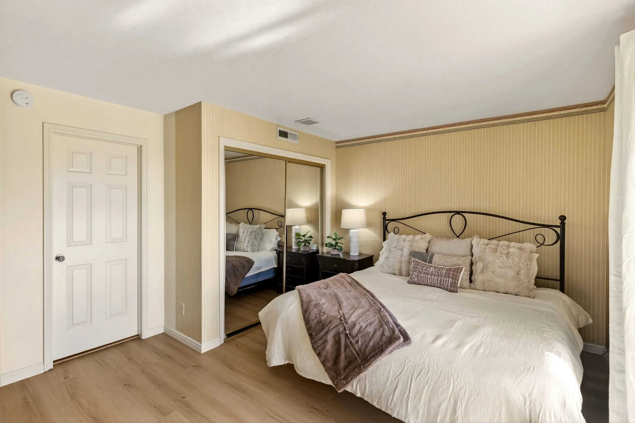 Bedroom featuring light wood-style floors, a closet, and wallpapered walls