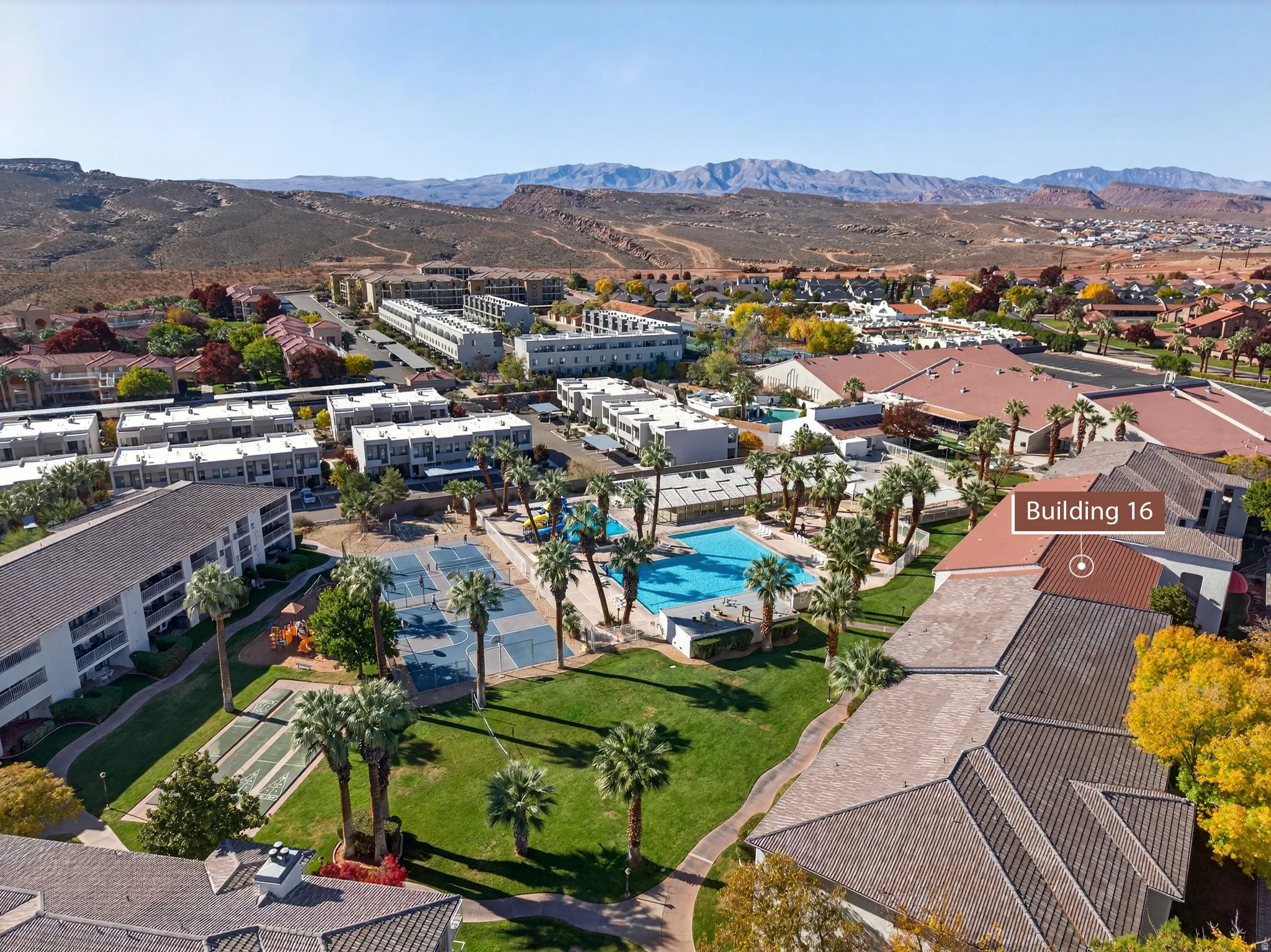 Aerial view of residential area with a pool and a mountainous background