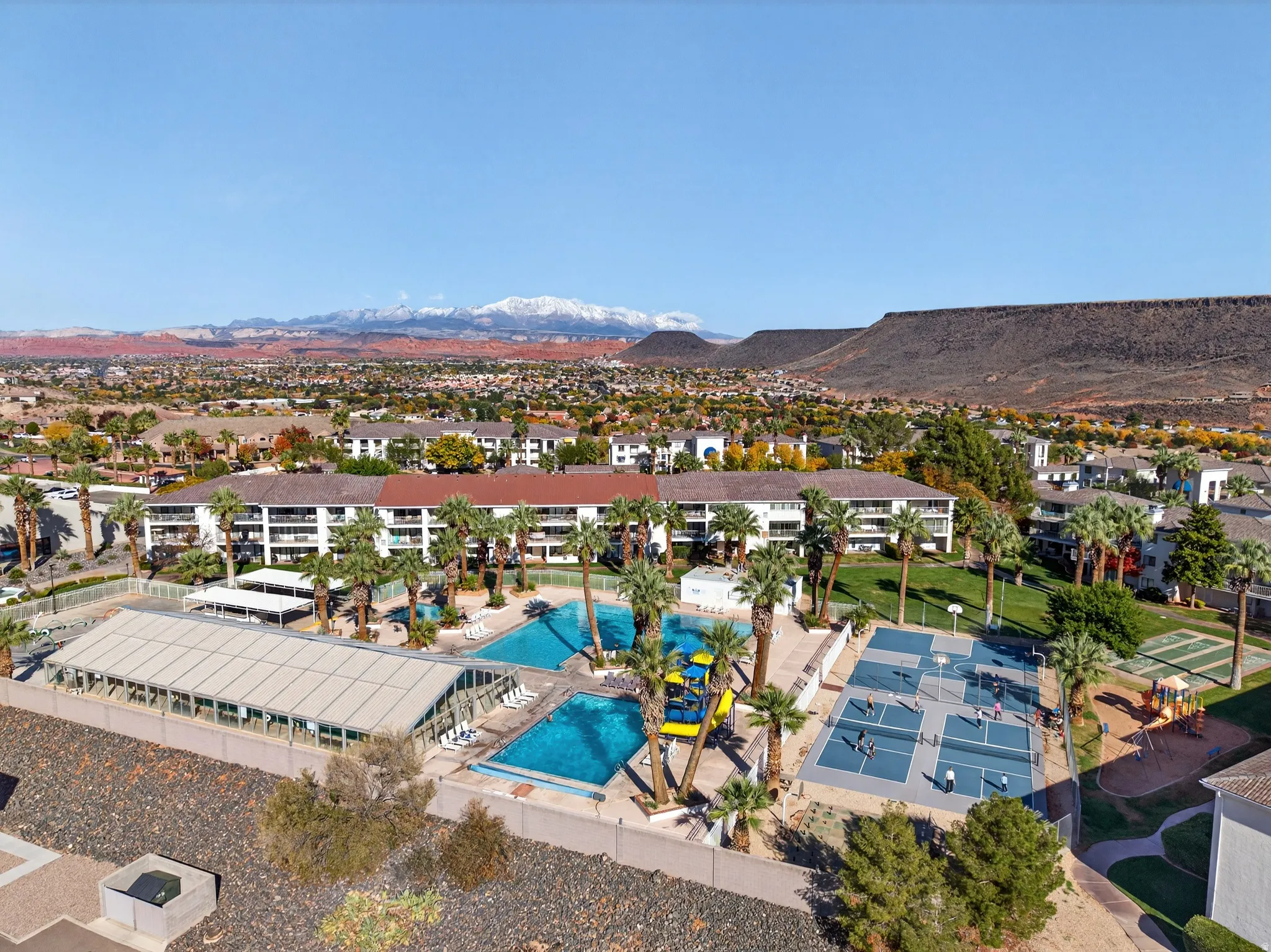 Aerial perspective of suburban area featuring a pool and a mountain backdrop