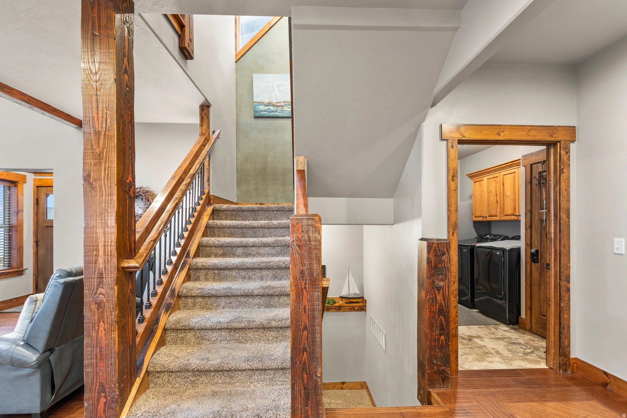 Stairs featuring washer and dryer and parquet floors