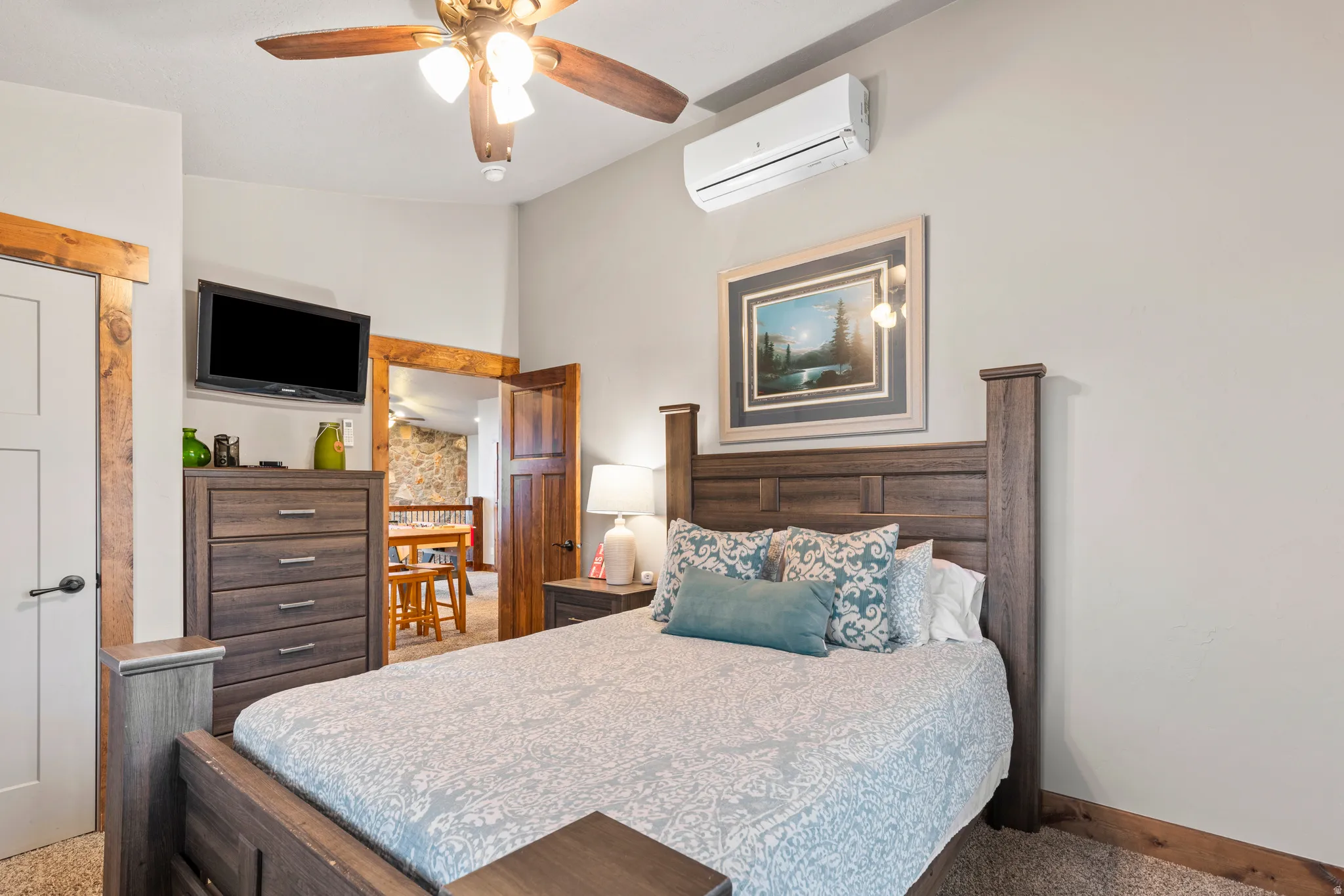 Bedroom with a wall unit AC, ceiling fan, and lofted ceiling