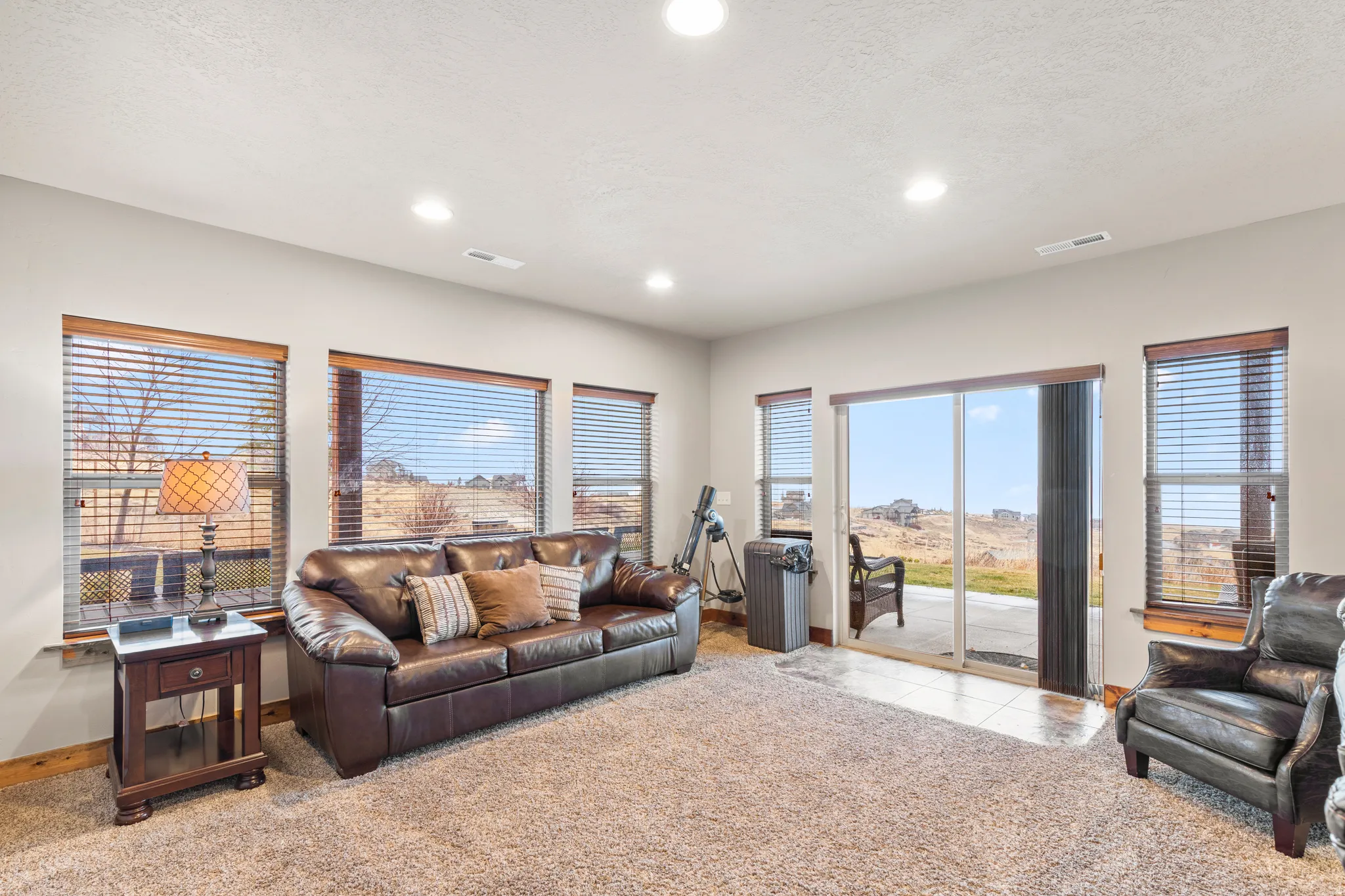 Living area featuring healthy amount of natural light, light colored carpet, recessed lighting, and a textured ceiling