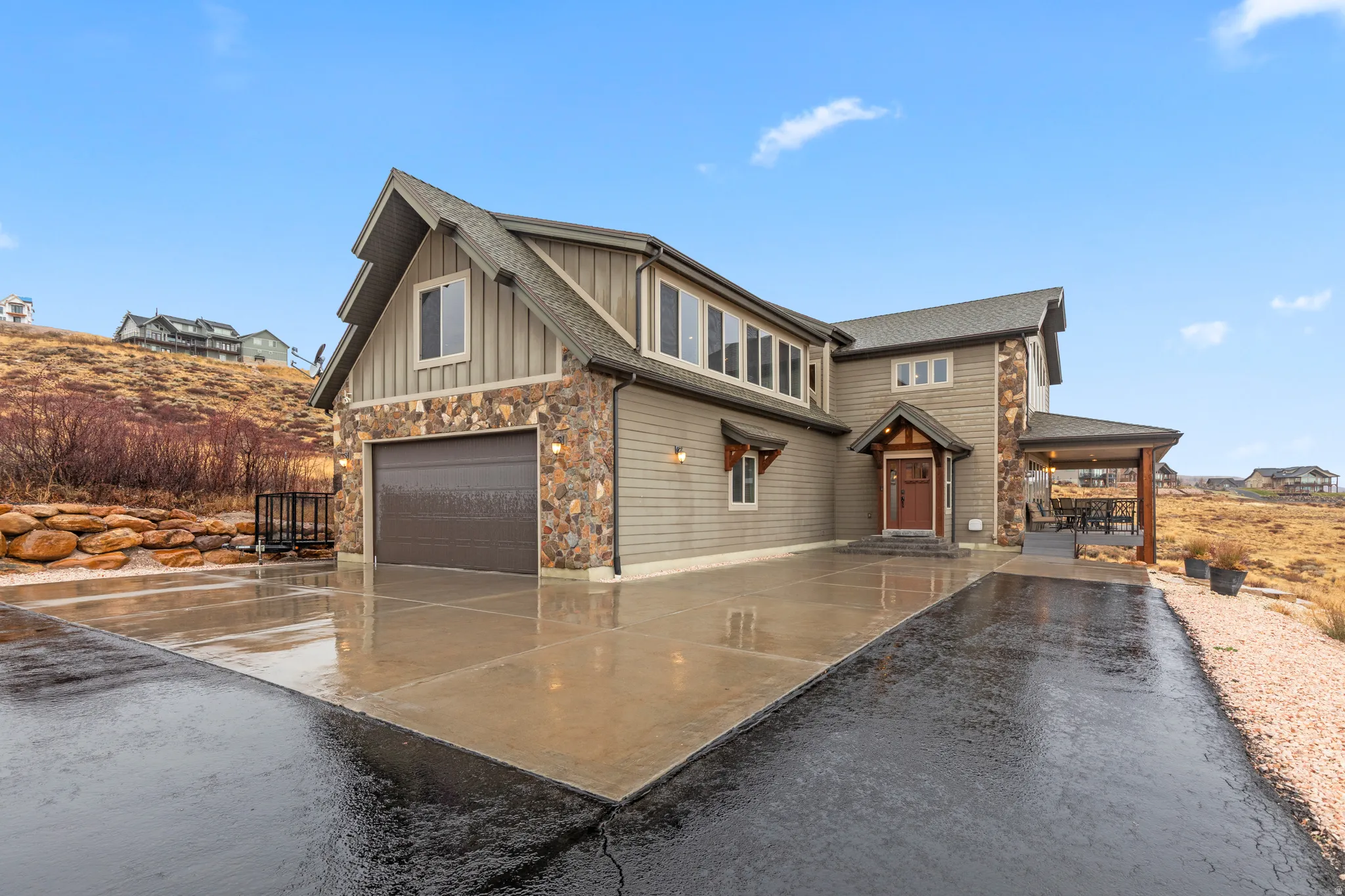 Craftsman inspired home with board and batten siding, stone siding, driveway, an attached garage, and a shingled roof